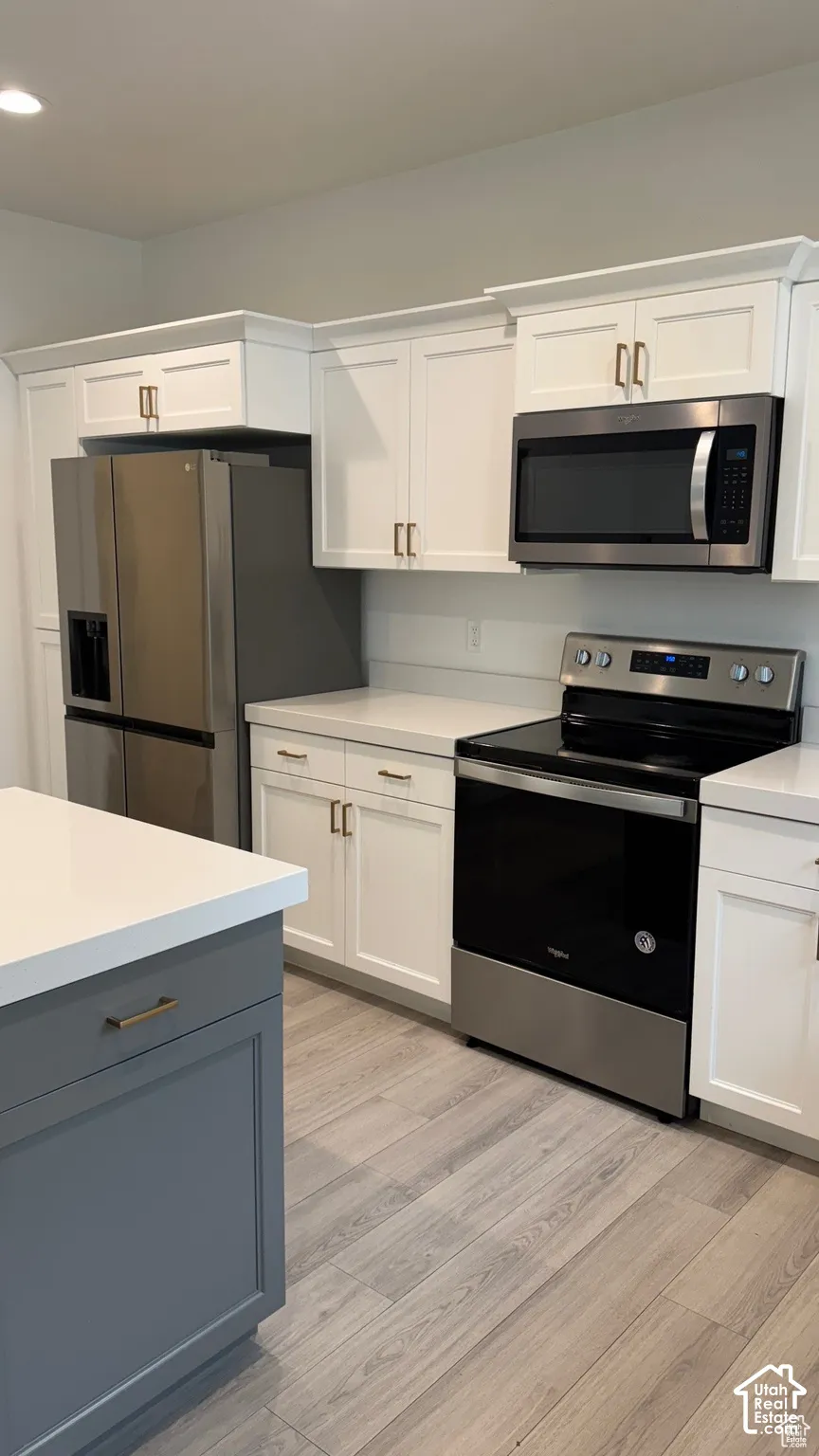 White shaker cabinetry with gold-tone hardware
