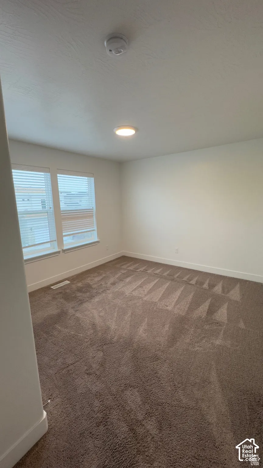 Recessed lighting, white walls, brown carpet, and white trim