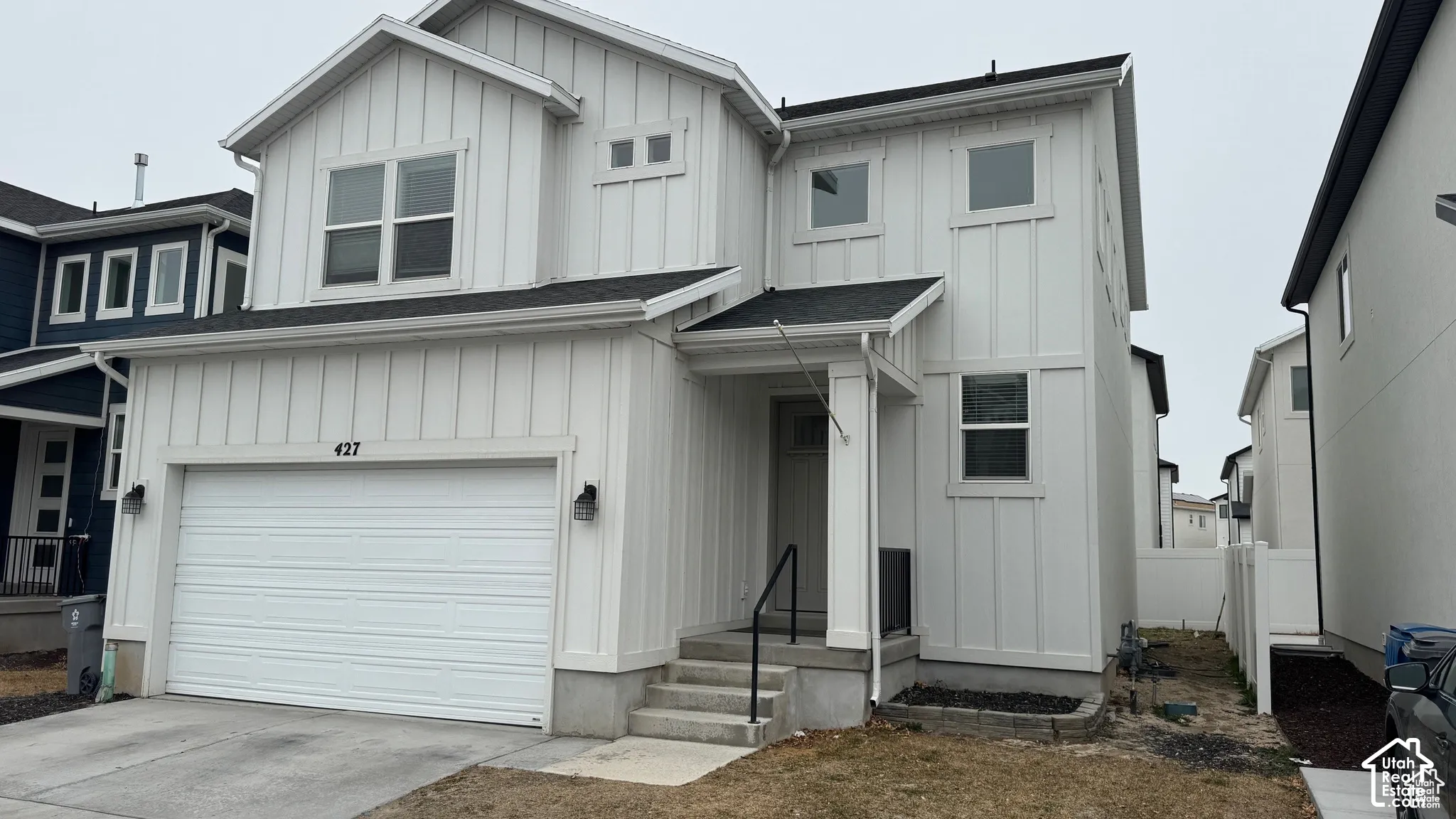 White vertical plank siding exterior with a dark roof