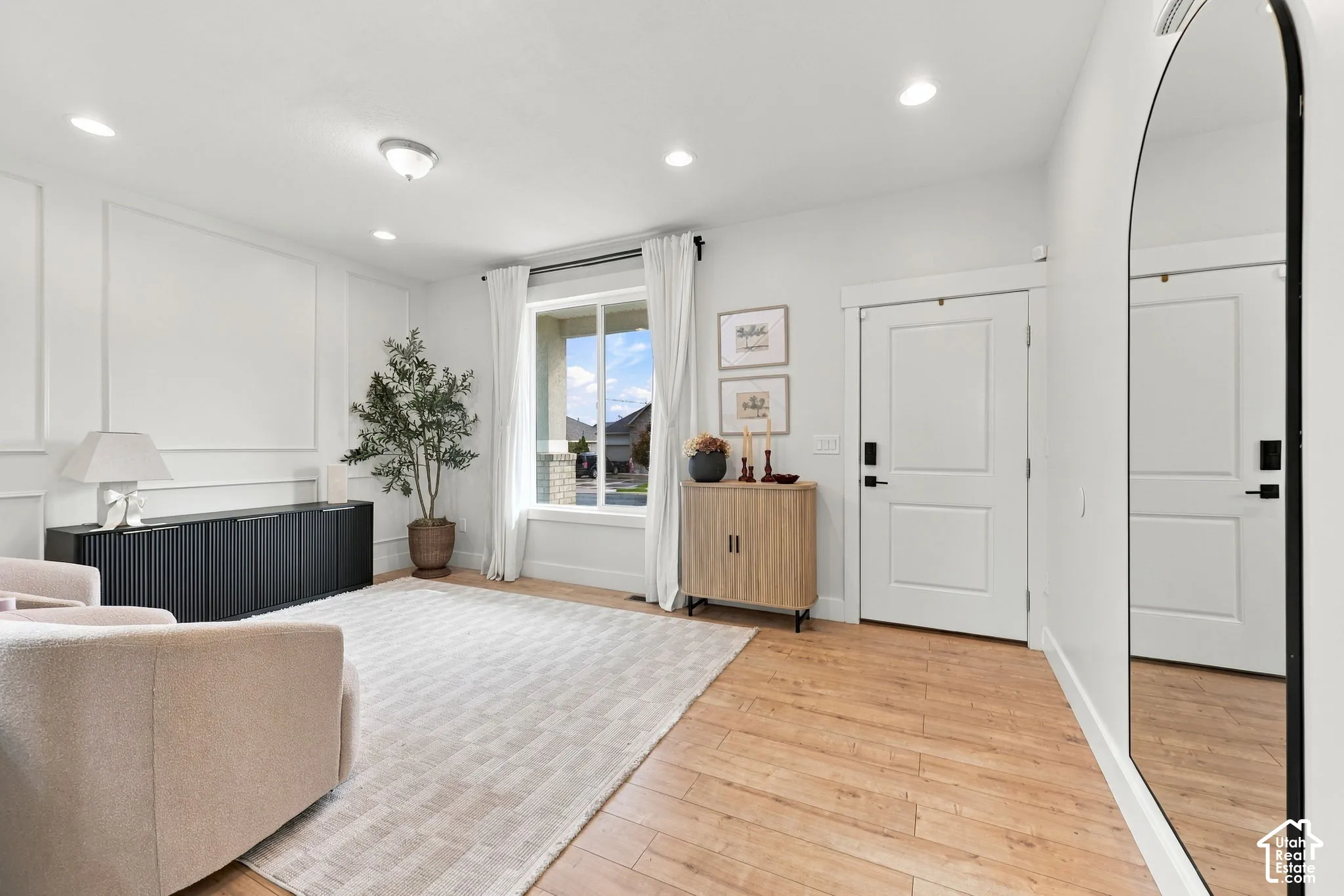 Interior space featuring wood-finish flooring, recessed lighting, and wall wainscoting detail