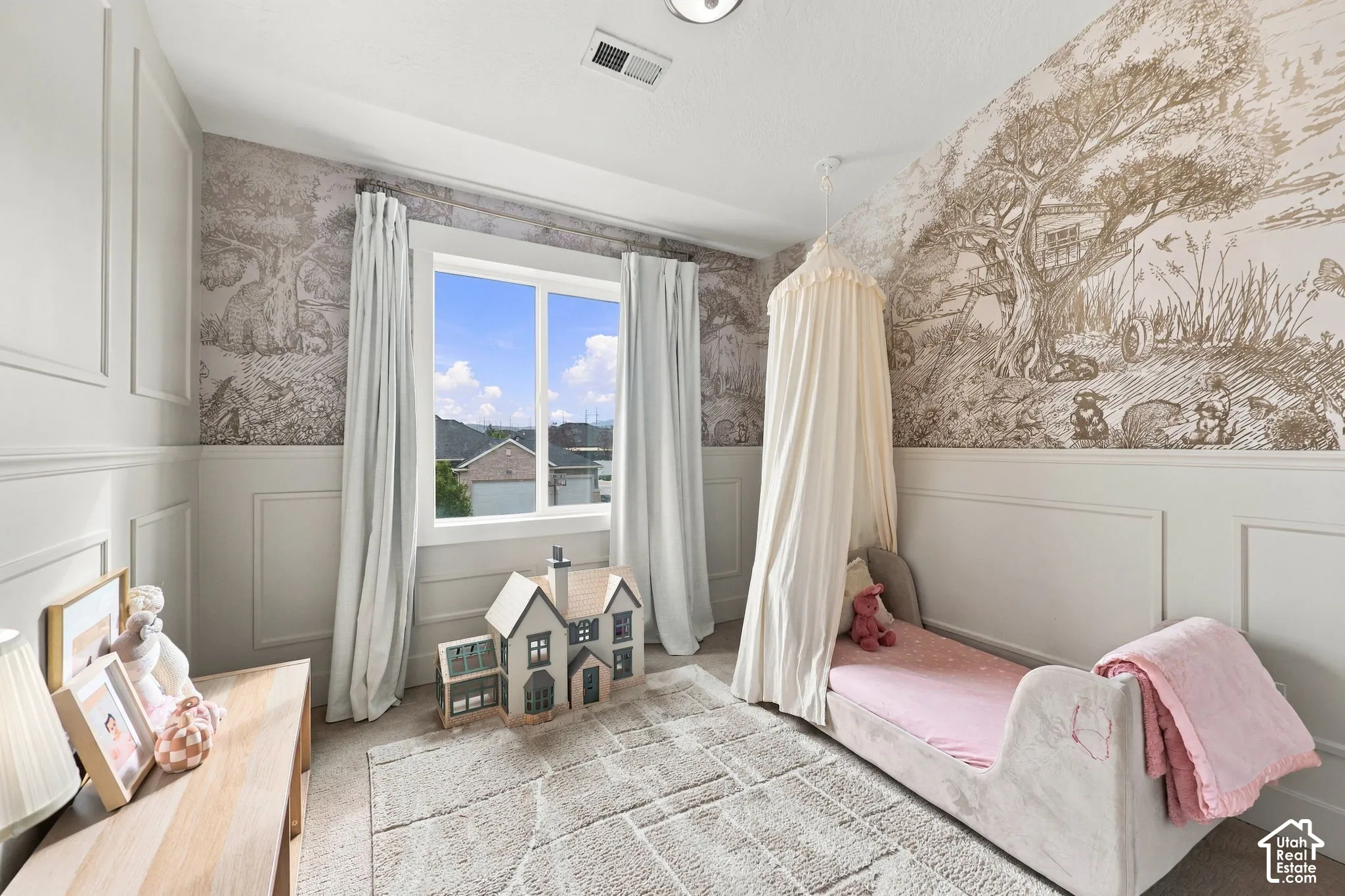 Room featuring detailed wall molding, floor-to-ceiling patterned wall covering, neutral carpeting, and a large window