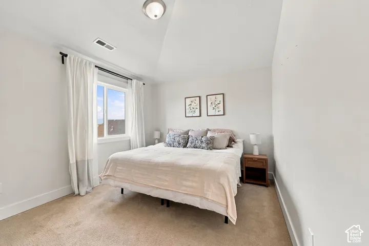 Vaulted ceiling featuring a central flush-mount light fixture and a single window with a white frame