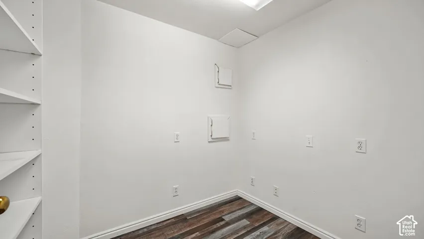 Storage room featuring multi-level built-in shelving, wood-finish flooring, and crisp white walls (not accessible from ADU)
