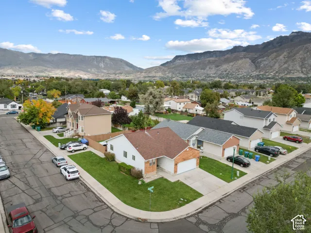 Corner lot property featuring a front-facing attached two-car garage, concrete driveway, and expansive mountain scenery
