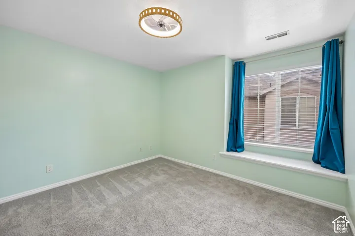 Room featuring neutral carpeting, a built-in window seat, and a circular flush-mount ceiling fixture