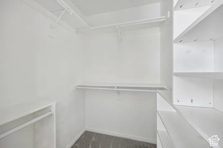 Walk-in closet featuring tiered shelving, built-in organizers, and overhead clothing rods