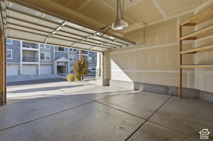 Concrete flooring, built-in shelving, automatic garage door opener, and a light-toned interior