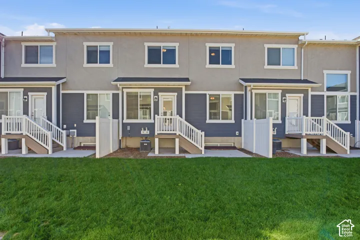 Exterior facade featuring multiple windows, private patios, and staircase access