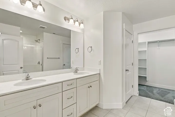 Primary Bath Dual sink vanity with white cabinetry and light-colored countertops