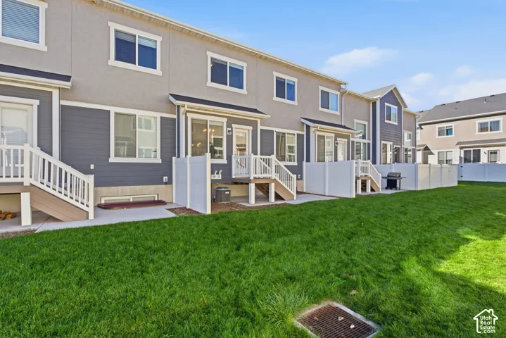 Expansive rear lawn featuring a privacy fence, concrete patio, and direct access to the home