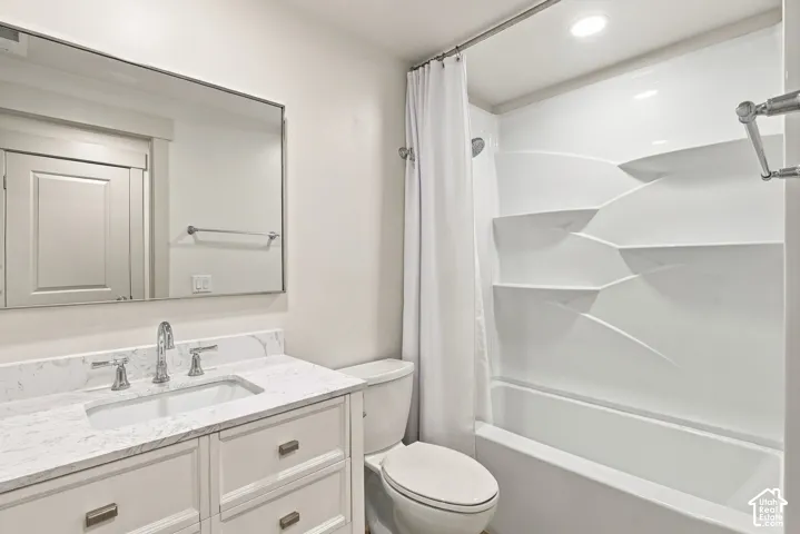White vanity with a stone-finish countertop and undermount sink
