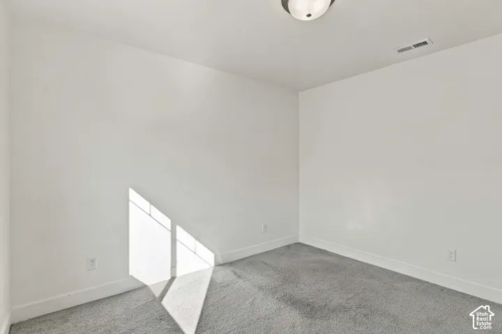 Wall-to-wall carpet flooring, white painted walls, and a flush-mount ceiling light fixture