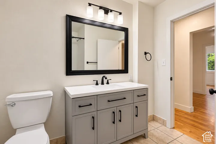 Bathroom vanity featuring a quartz countertop, integrated sink, matte black hardware, framed wall mirror, and modern multi-light fixture
