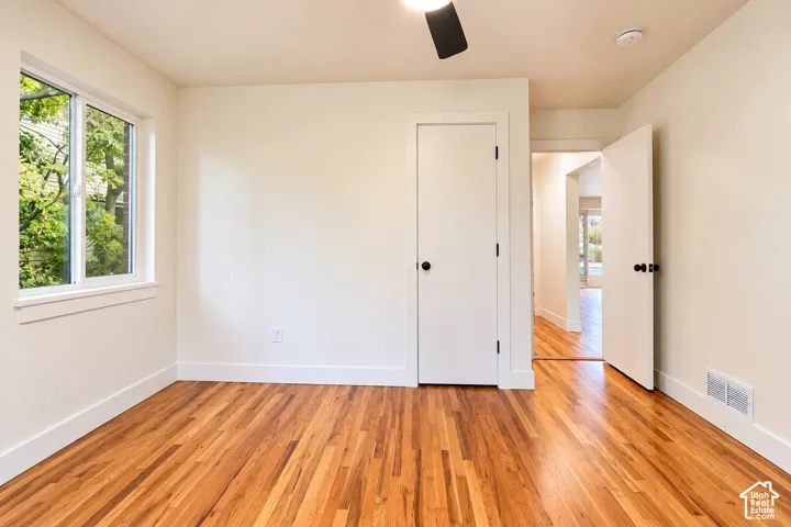 Room 2 featuring wood-finish flooring, a ceiling fan, and a single-pane window