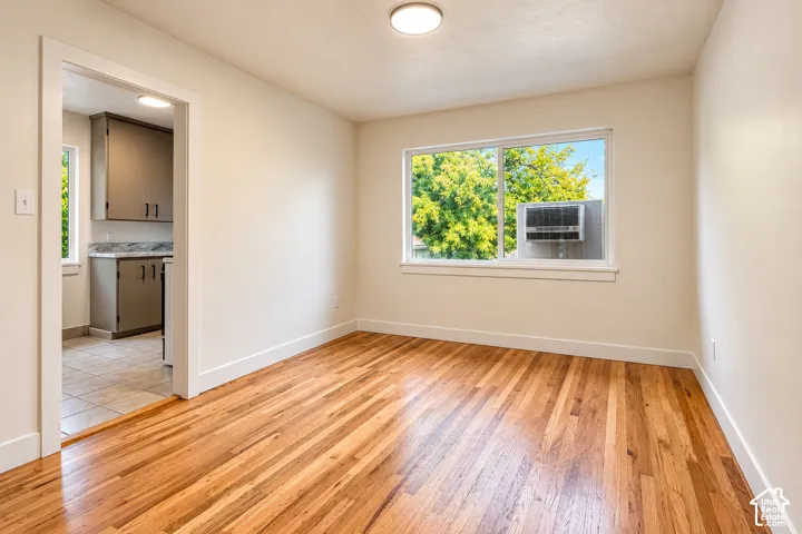 Interior space featuring wood-finish flooring, a large sliding window, and neutral wall tones