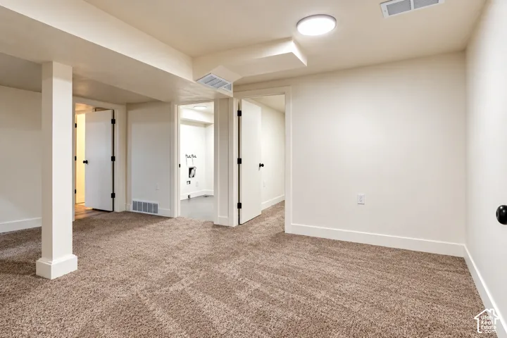 Finished interior space featuring neutral wall paint, textured carpeting, recessed ceiling lighting, and multiple interior doorways