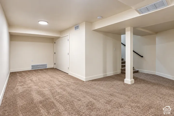 Interior space featuring neutral wall tones, wall-to-wall carpeting, recessed ceiling lighting, and a structural column