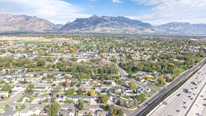 Aerial perspective showcasing residential neighborhood topography with prominent mountain range backdrop and mature vegetation