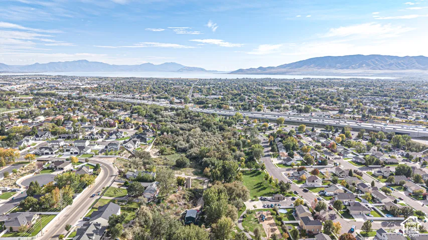 Aerial perspective featuring expansive mountain range, horizon water, and established tree canopy