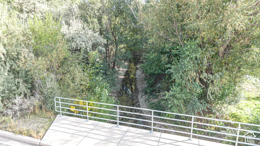 Concrete platform featuring a metal guardrail and natural landscape with mature trees and vegetation
