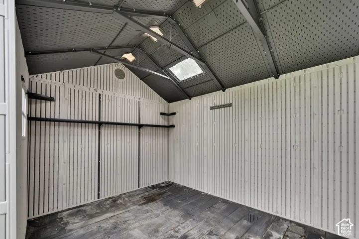 Storage structure featuring high-vaulted ceilings, integrated skylights, reinforced steel framing, built-in shelving, and vertical-panel wall construction