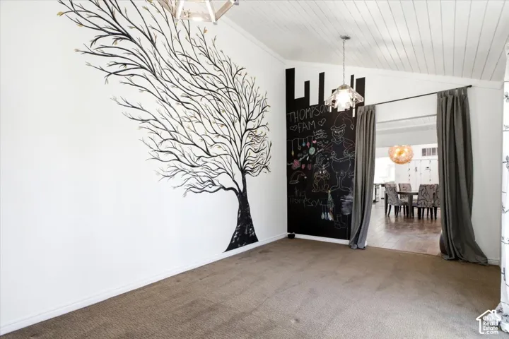Vaulted ceiling with shiplap detail, large-scale wall mural, chalkboard accent wall, and geometric pendant lighting