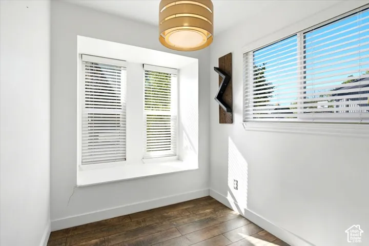 Built-in window seat, wood-finish flooring, cylindrical drum light fixture, and horizontal window blinds