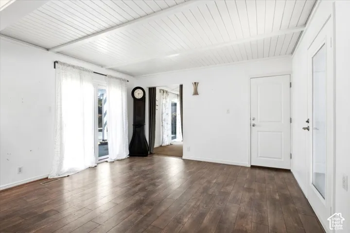 Wood-finish flooring, white planked ceiling, solid core paneled door, and glass-paneled exterior door