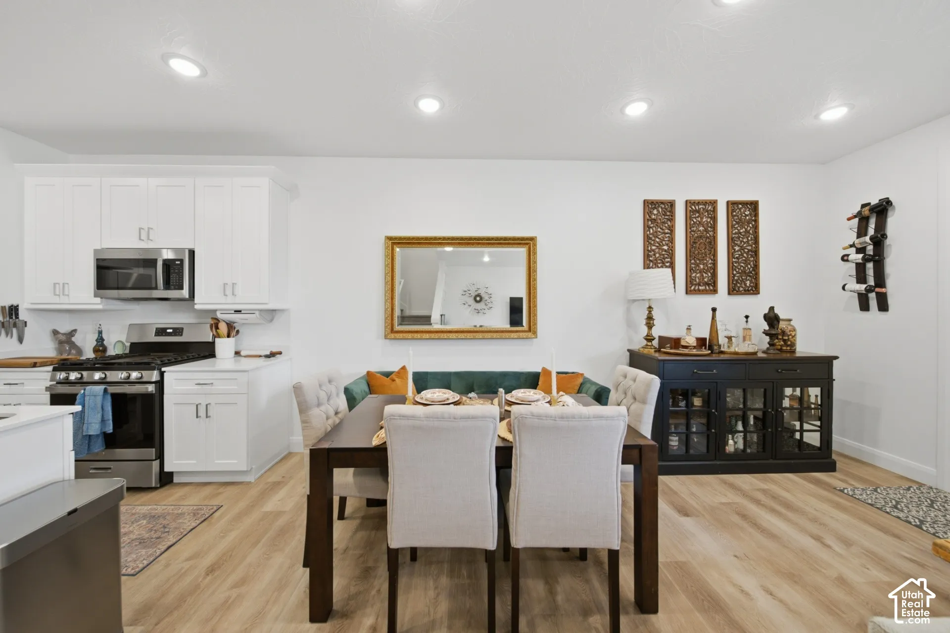 Shaker-style white cabinetry, stainless steel appliances, recessed lighting, and wood-finish flooring