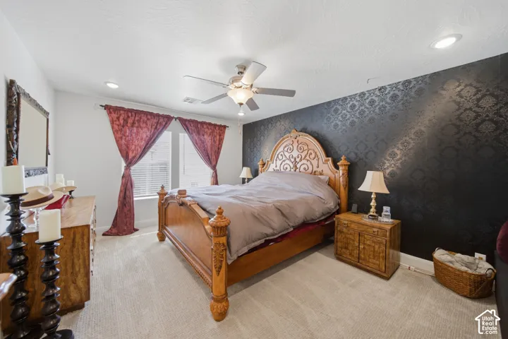 Bedroom featuring a black damask-patterned accent wall, recessed lighting, and a ceiling fan with integrated lighting