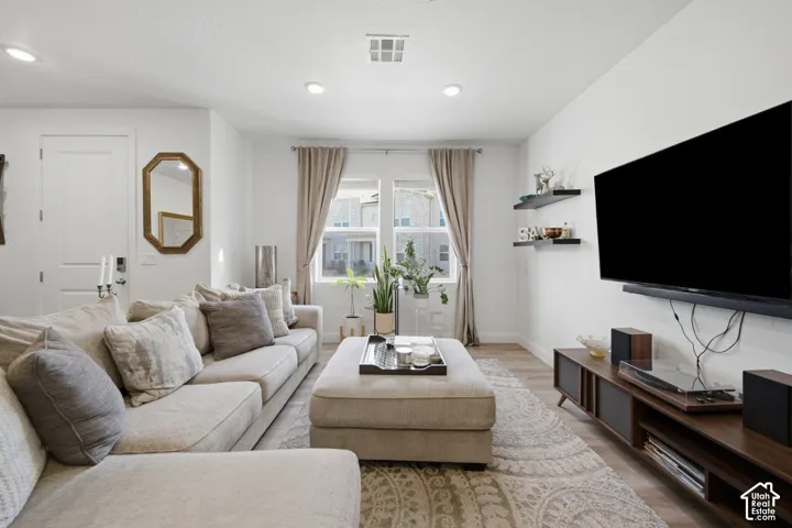 Neutral-toned interior featuring wood-finish flooring, recessed lighting, double-pane windows, and wall-mounted shelving