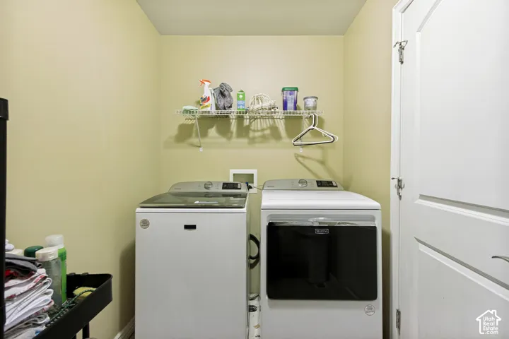 Dedicated laundry area with a top-load washing machine and front-load dryer