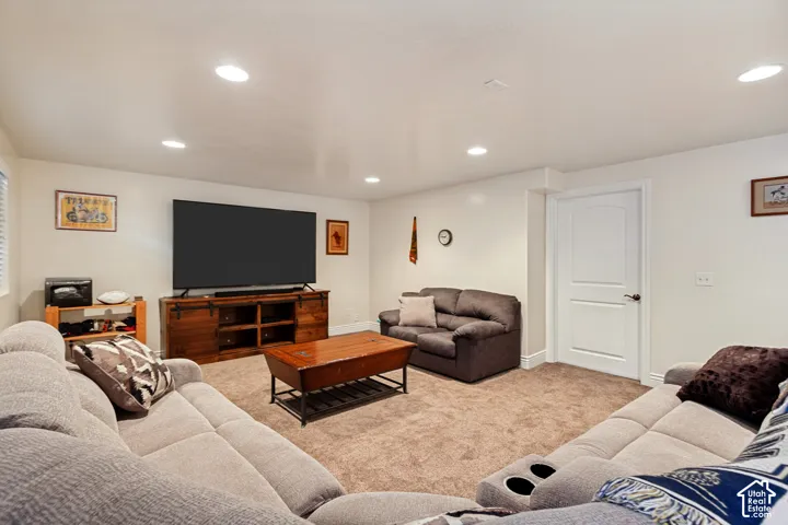 Recessed ceiling lighting, white walls, and neutral carpet flooring