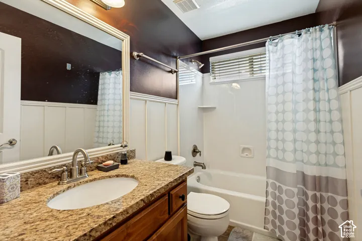 Vanity with a granite-style countertop, undermount sink, and brushed nickel faucet