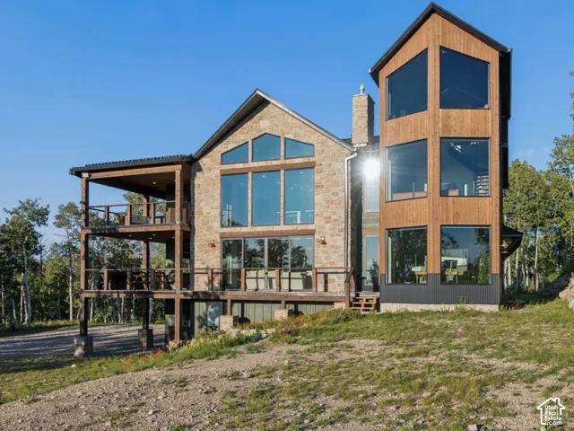 Stone and wood-clad exterior with a multi-level deck