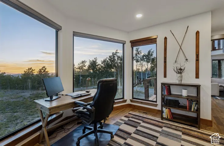Expansive windows, wood-finish flooring, built-in recessed lighting, and a built-in bookshelf