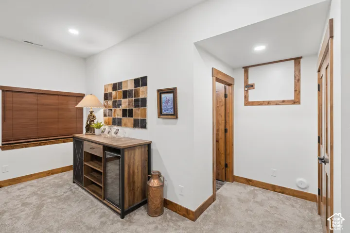 Carpeted flooring, recessed lighting, wood-finish trim, and interior doors