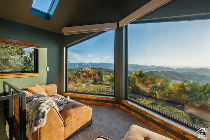 Sloped ceilings with a skylight, expansive multi-pane windows, wood-finish window sills, and integrated window treatments