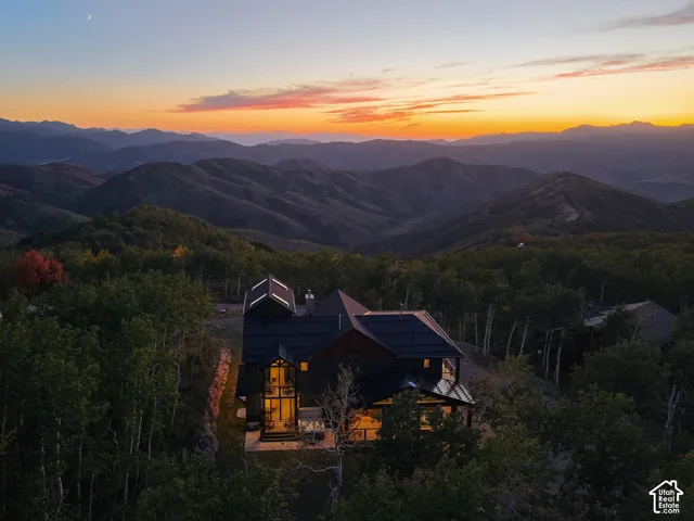 Expansive mountain scenery with a prominent residential structure