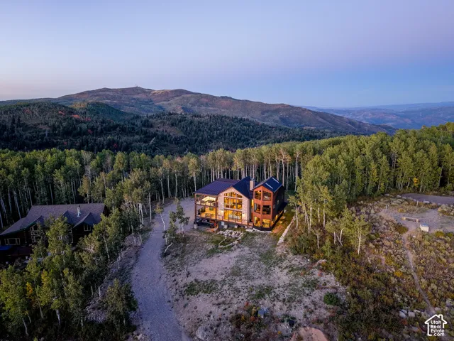 Contemporary architecture with extensive glazing, set amidst a mountainous, wooded landscape