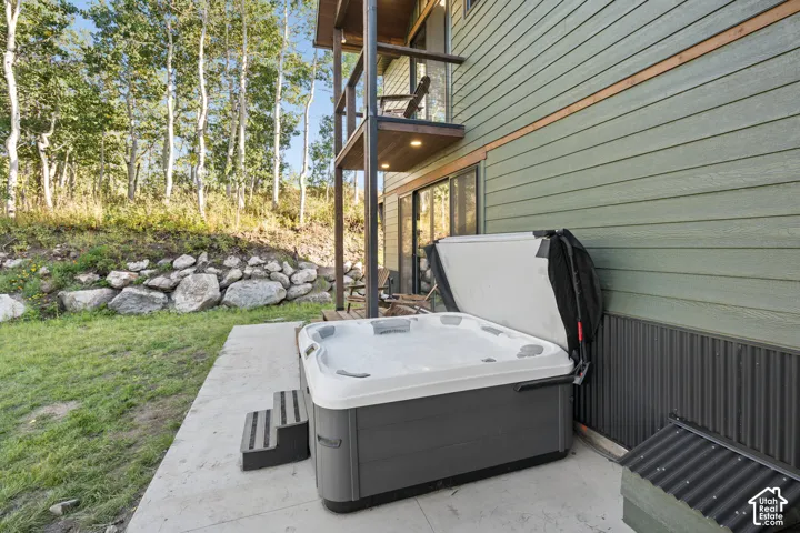 Outdoor hot tub on a concrete patio with steps