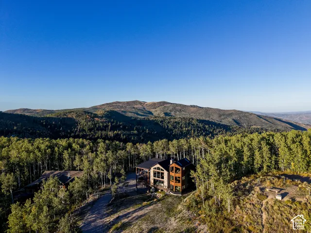Modern mountain residence featuring a multi-story design, extensive window placement, and a large exterior deck