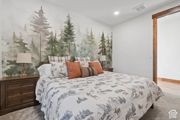Feature wall with a forest mural, recessed ceiling lighting, wood-finish door trim, and carpeted flooring