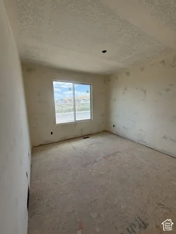 Interior space featuring drywall panels, a single-pane slider window, and subflooring