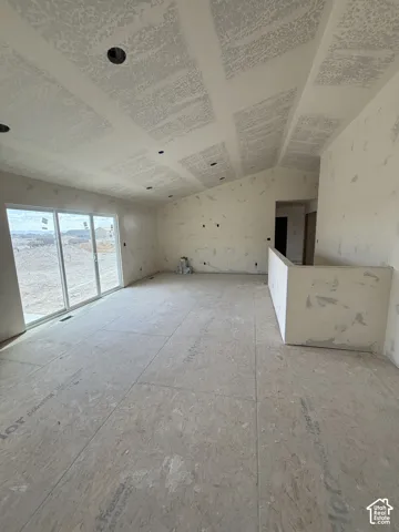 Vaulted ceiling featuring recessed lighting, sliding glass door, and partial-height wall partition