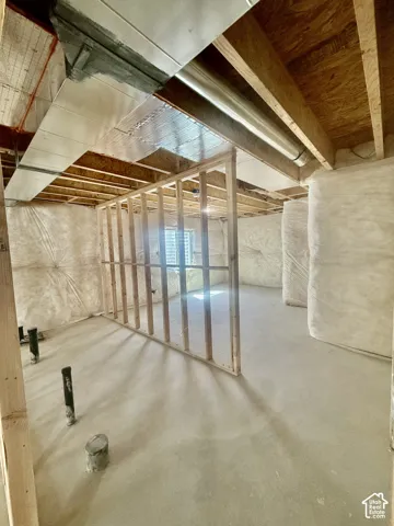 Unfinished lower level featuring exposed wood framing, concrete flooring, batt insulation, and exposed metal ductwork