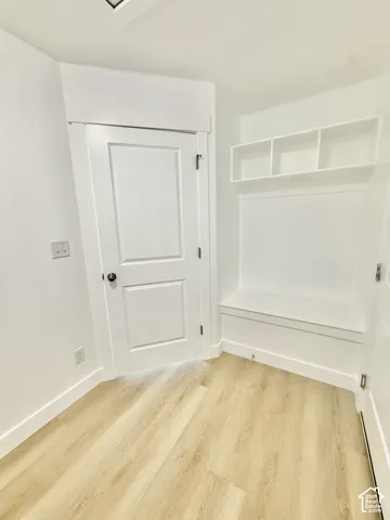 Built-in bench seating with overhead partitioned shelving, wood-finish flooring, and shaker-style interior doors