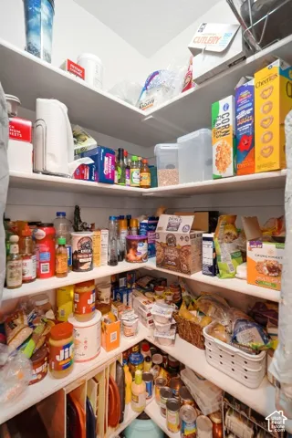 Walk-in pantry featuring multiple tiers of built-in shelving and shiplap wall detailing