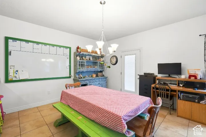 Ceramic tile flooring, six-light polished nickel chandelier, and glass-paneled exterior door