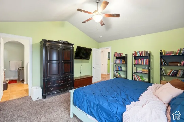 Vaulted ceiling with an integrated multi-blade ceiling fan and wall-to-wall carpeted flooring